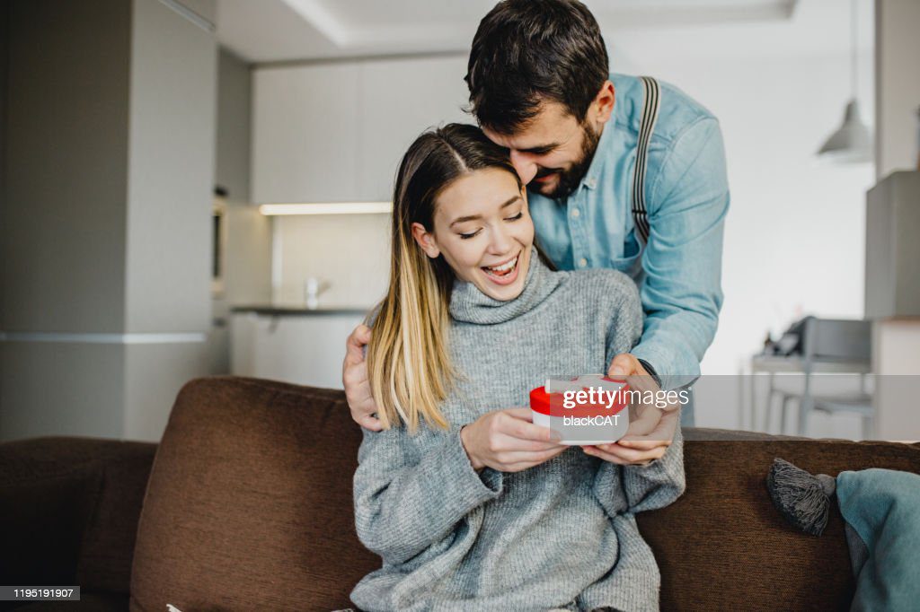 joven pareja romántica sosteniendo presente - novio fotografías e imágenes de stock