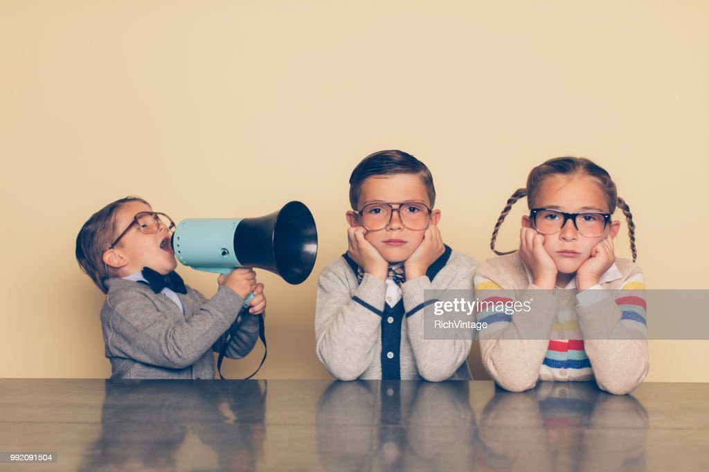 chico joven nerd gritando a hermanos con megáfono - ignora fotografías e imágenes de stock