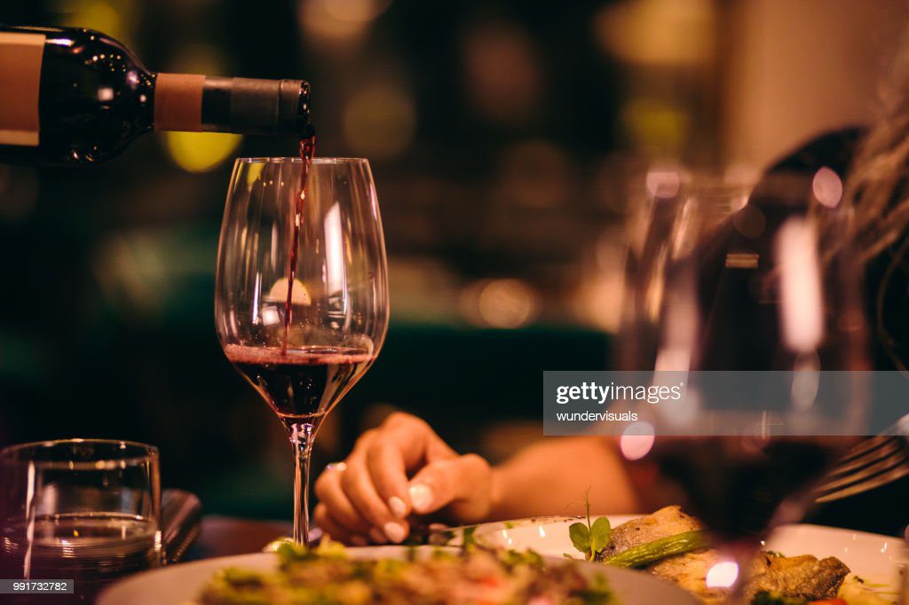 primer plano de sumiller sirviendo vino tinto en el restaurante - cena fotografías e imágenes de stock
