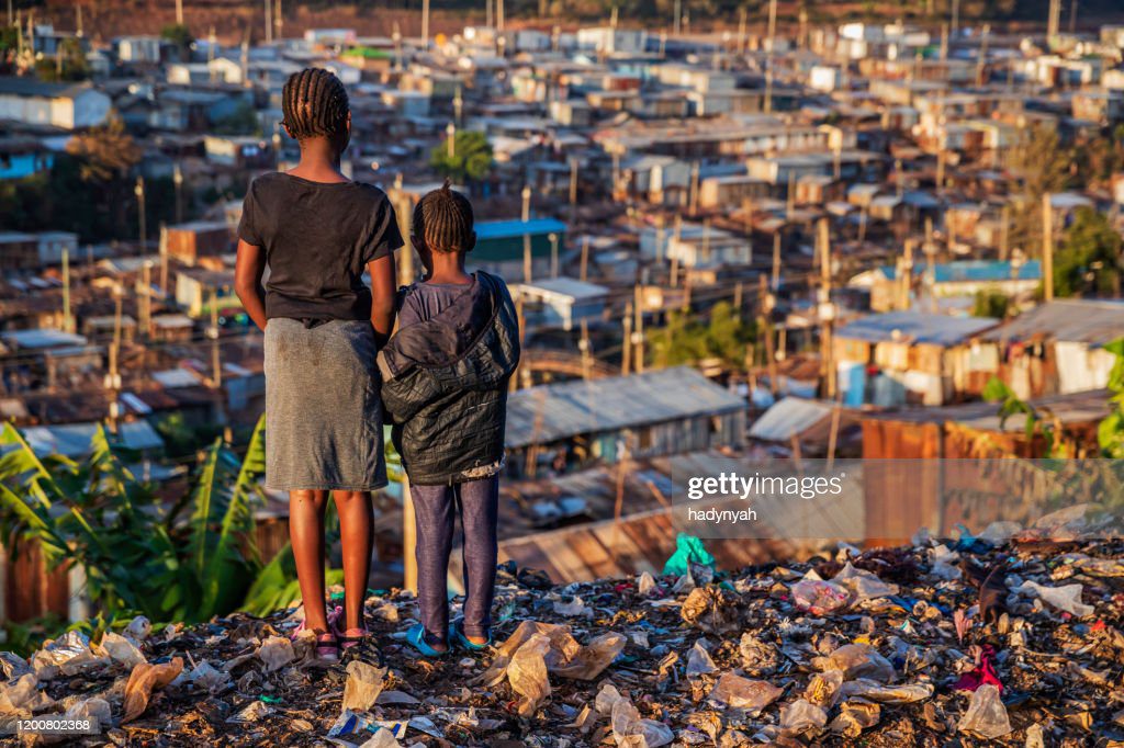 niñas africanas de pie en la basura y mirando a la barriada de kibera, kenia, - pobreza fotografías e imágenes de stock