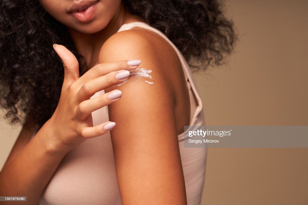 woman applying moisturizing cream on shoulder - piel fotografías e imágenes de stock