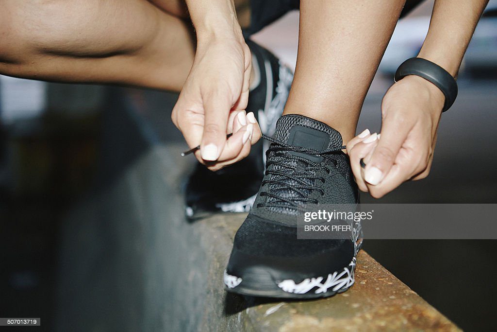 young woman tying athletic shoelace - cordon zapato fotografías e imágenes de stock