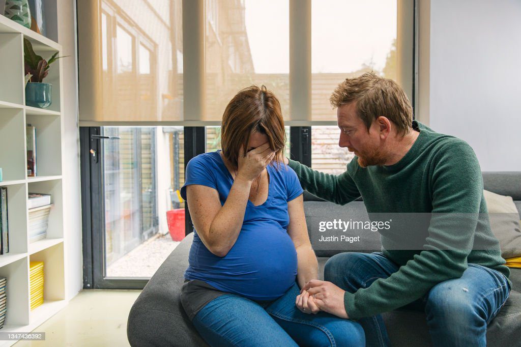 man comforts his upset pregnant wife - embarazada llora fotografías e imágenes de stock