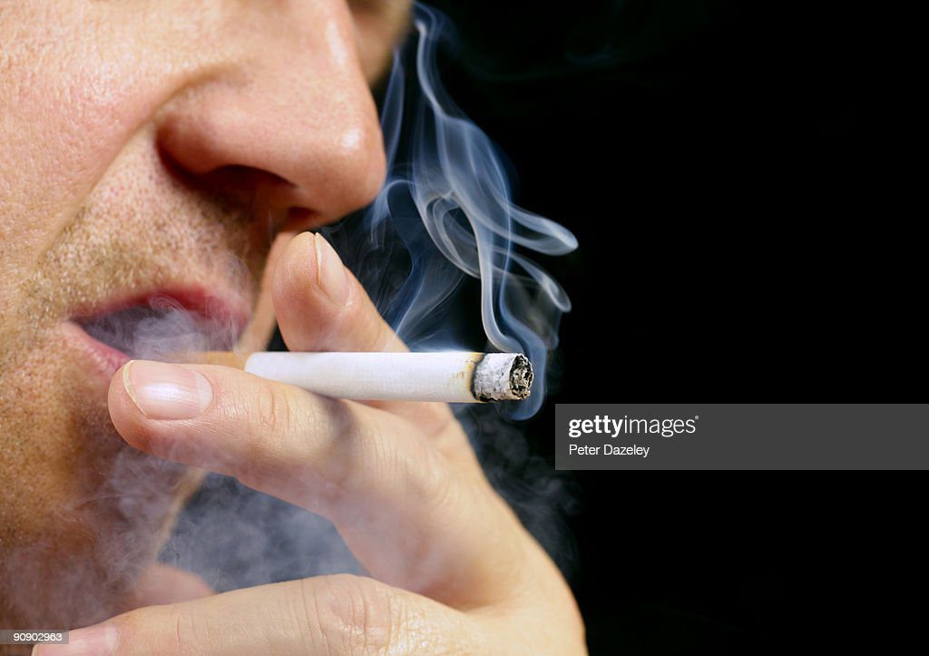 senior male smoking cigarette on black background - fumando cigarro fotografías e imágenes de stock