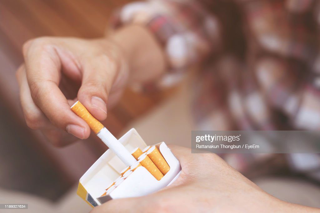 close-up of person holding cigarette pack - fumando cigarro fotografías e imágenes de stock