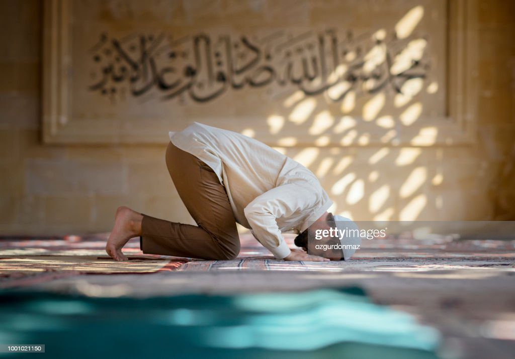 hombre está rezando en la mezquita - rezar fotografías e imágenes de stock
