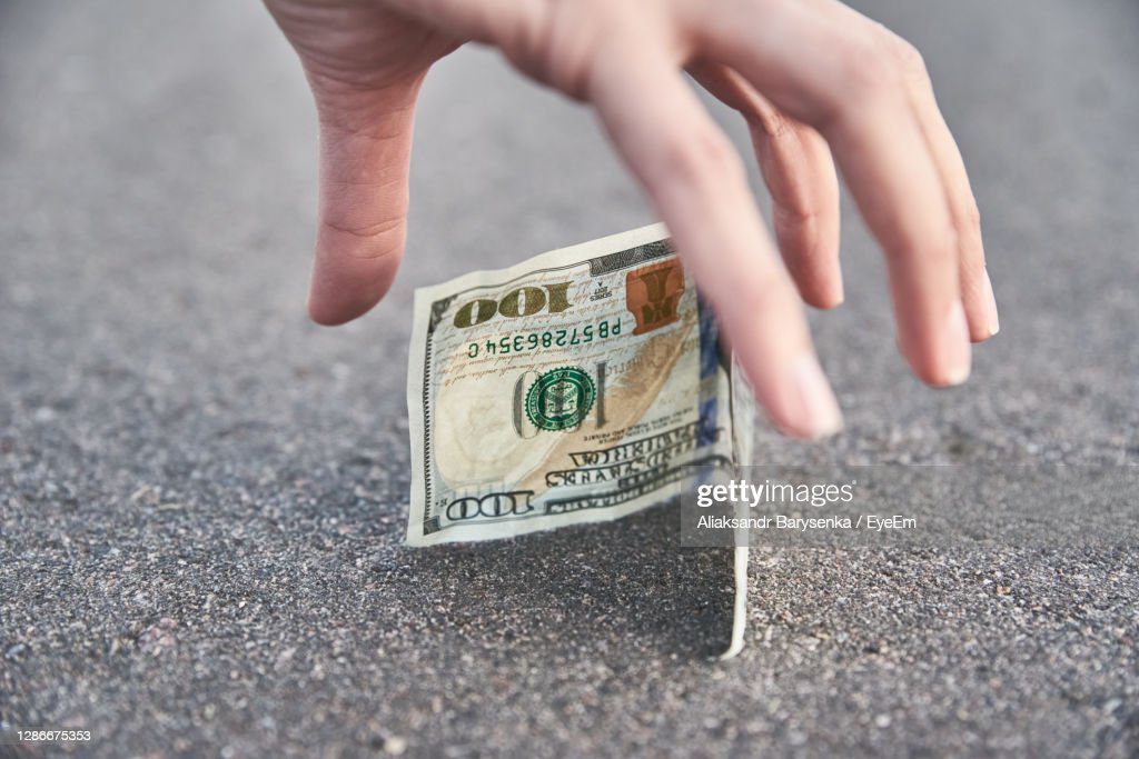 close-up of hand holding banknote - encontrar dinero fotografías e imágenes de stock