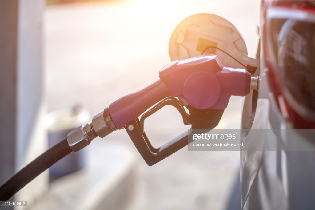 fuel oil gasoline dispenser at petrol filling station.holding fuel nozzle to refuel gasoline for car. - petroleo fotografías e imágenes de stock