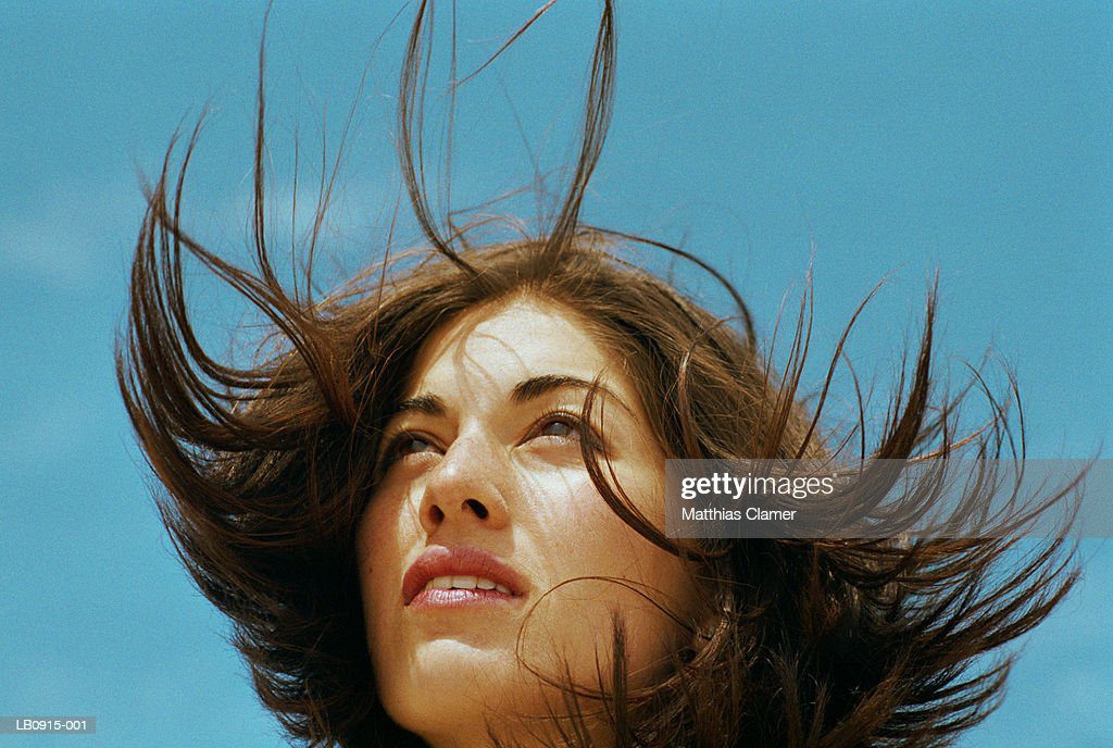 young woman standing outdoors, hair blowing, close-up - preddicion fotografías e imágenes de stock