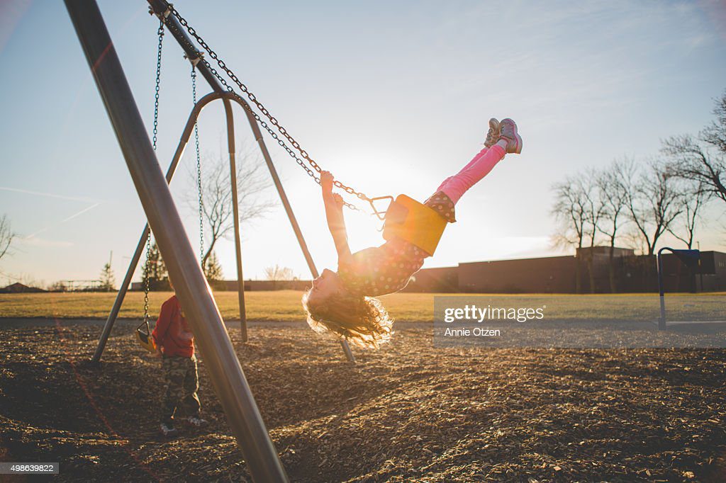 children playing on a swing set - columpio fotografías e imágenes de stock
