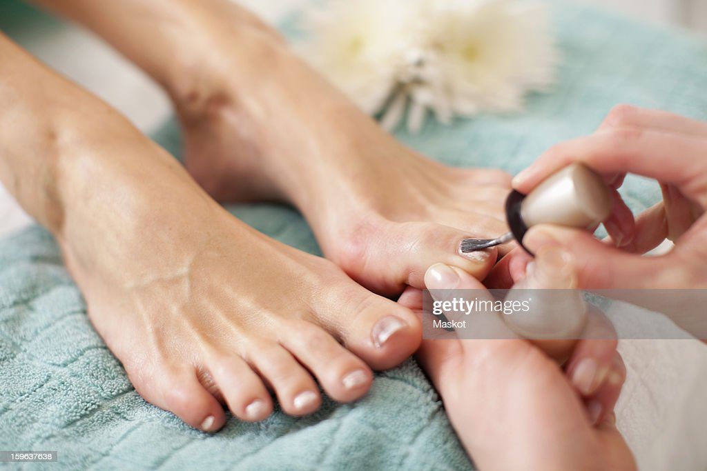 close-up of a female feet receiving a beauty treatment for nails in spa - uñas de los pies fotografías e imágenes de stock