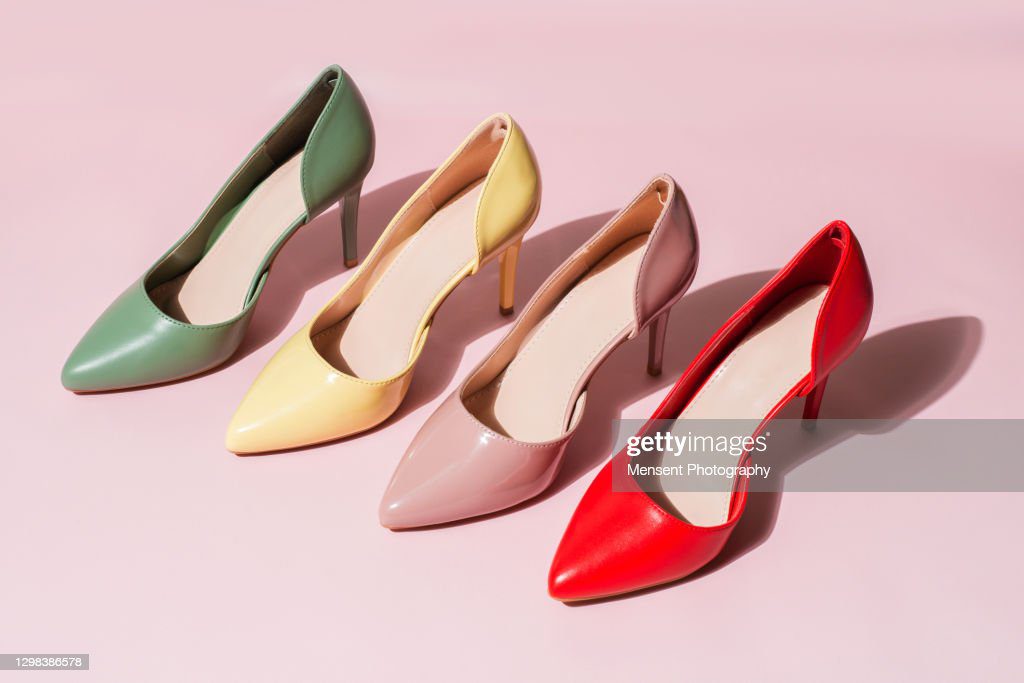 multicolored womens shoes stand in a row on vinyl pink background - zapatos fotografías e imágenes de stock