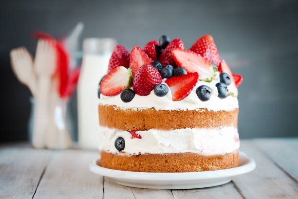 sponge cake with strawberries, blueberries and cream - tarta fotografías e imágenes de stock
