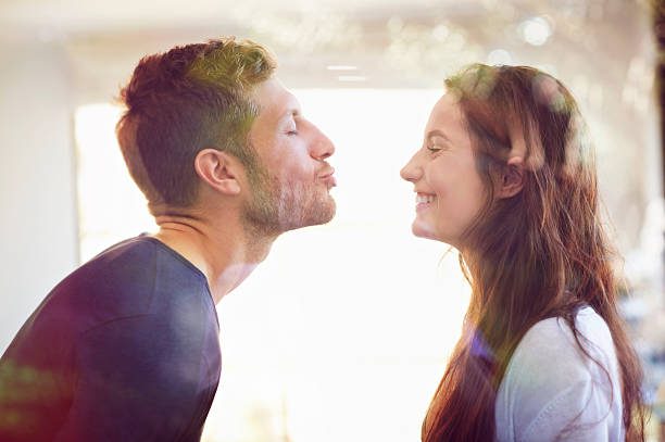 young couple about to kiss - beso fotografías e imágenes de stock