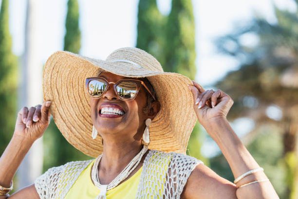 mujer senior afroestadounidense llevando gafas de sol - sombrero fotografías e imágenes de stock