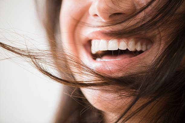 close up of laughing woman with messy hair - boca fotografías e imágenes de stock