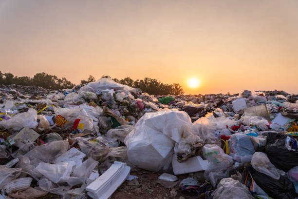 close up large garbage pile near the sunset, global warming - basura fotografías e imágenes de stock