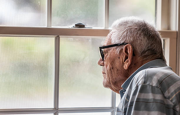 hombre mayor melanclero mirando a través de la ventana nebulosa - verrugas fotografías e imágenes de stock