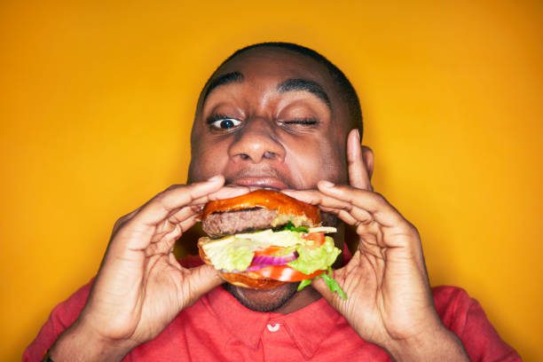 man eating hamburger - mordida fotografías e imágenes de stock